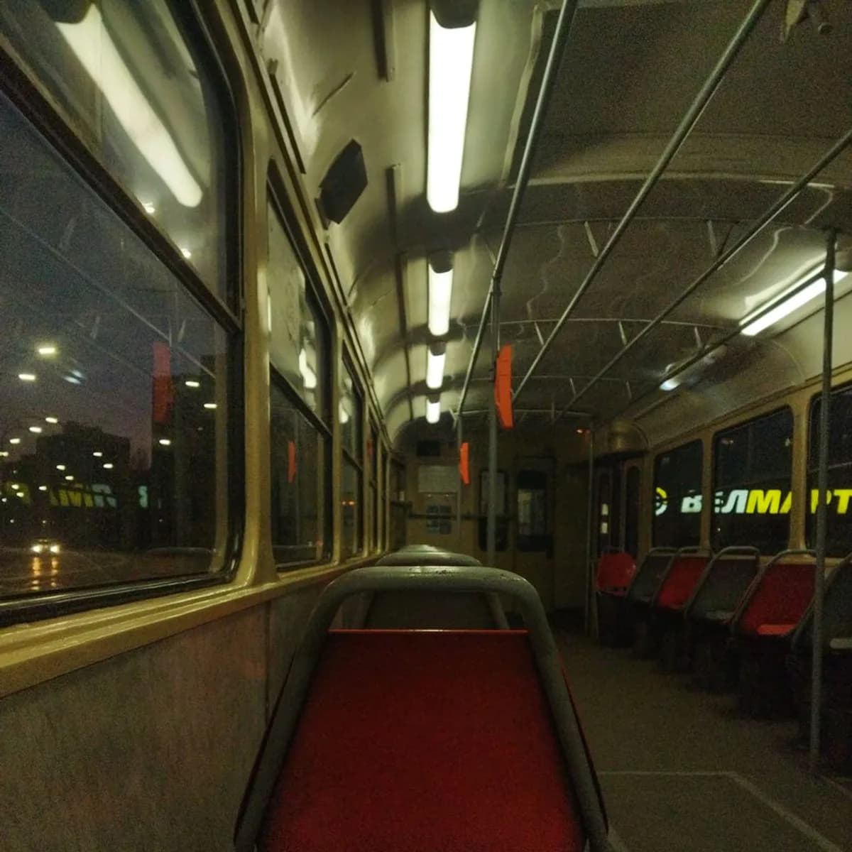 Empty night bus interior with city light through the window.